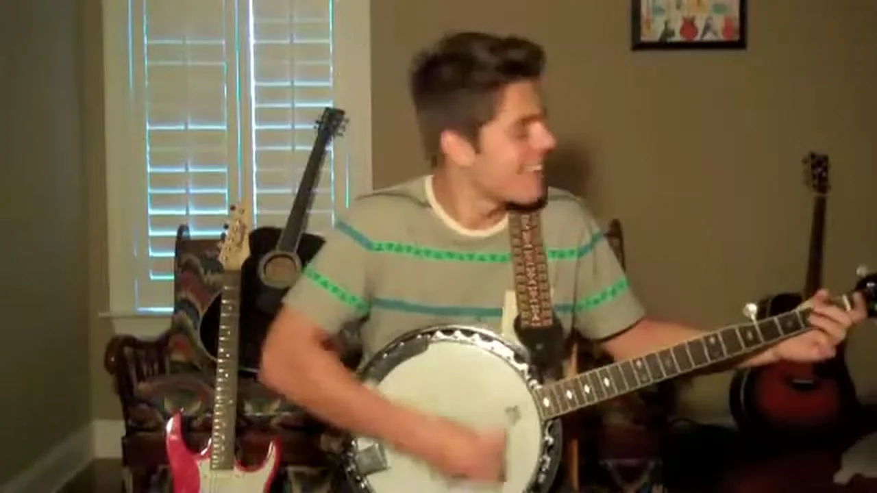 Cole playing his banjo Betty, his guitar visible behind him